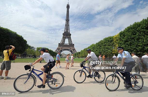 German policeman Martin Decker rides a bike in front of the Eiffel Tower in Paris on August 5, 2009. Decker is one of eight "exchange policemen" from...