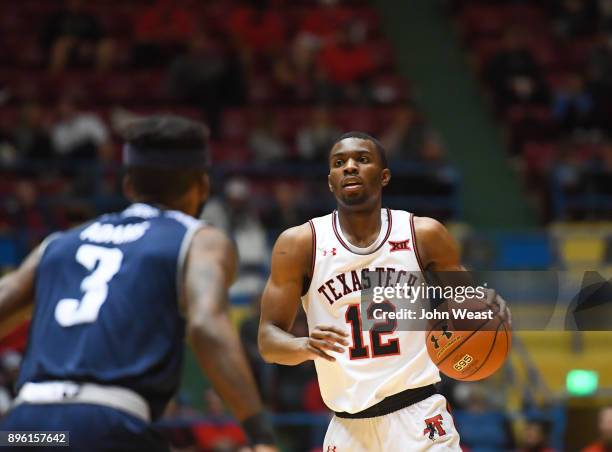 Keenan Evans of the Texas Tech Red Raiders handles the ball against Ako Adams of the Rice Owls during the game on December 16, 2017 at Lubbock...