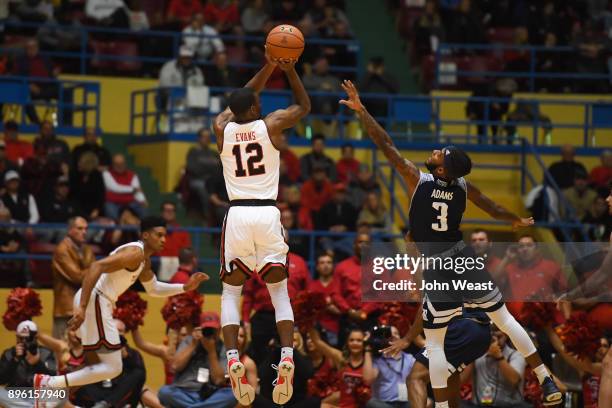 Keenan Evans of the Texas Tech Red Raiders shoots the ball over Ako Adams of the Rice Owls during the game on December 16, 2017 at Lubbock Municipal...