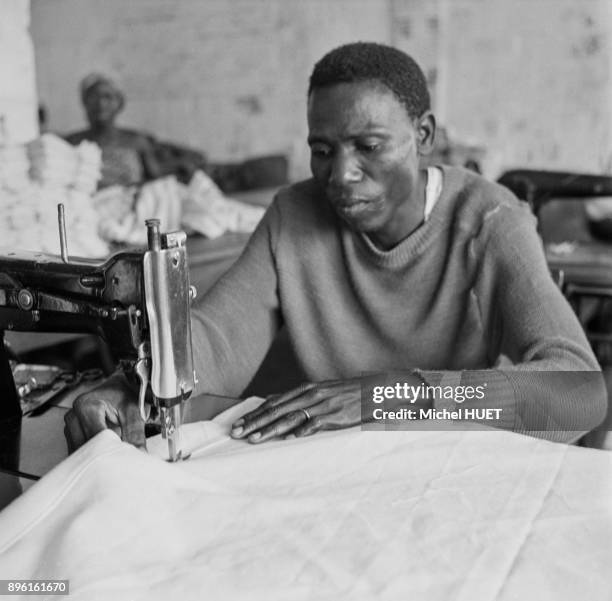 Ouvrier travaillant sur une machine a coudre dans l'usine textile de Gonfreville a Bouake, Cote d'Ivoire.