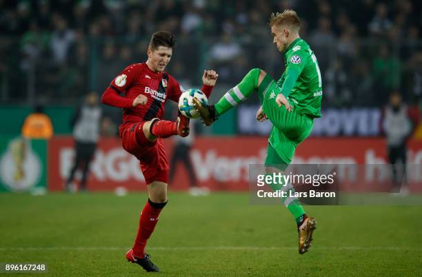 Panagiotis Retsos of Leverkusen challenges Oscar Wendt of Moenchengladbach during the DFB Cup match between Borussia Moenchengladbach and Bayer...