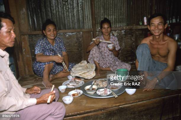 Famille de pecheurs a table a Nha Trang, en aout 1994, Viet Nam.