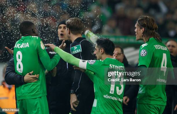 Head coach Heiko Herrlich of Leverkusen argues with Denis Zakaria of Moenchegladbach and gets hit by a glass of beer during the DFB Cup match between...