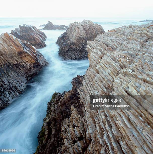 ocean waves crashing on rock formations on beach - parc d'état de montana de oro photos et images de collection