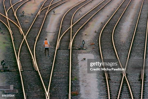 man standing in between train tracks - rail fotografías e imágenes de stock