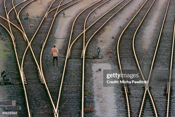 man standing in between train tracks - voie ferrée photos et images de collection
