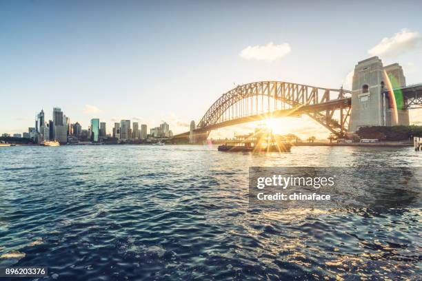 skyline von sydney gegen sonnenuntergang himmel - hafenbrücke von sydney stock-fotos und bilder