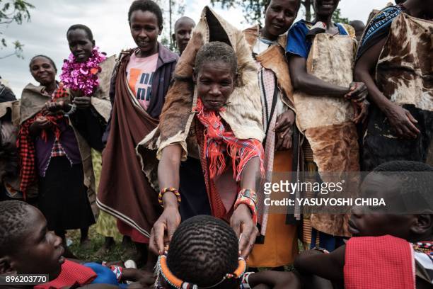 Circumcised Maasai young man receives an accessory from his mother after coming out from the bush near Kilgoris, Kenya, on the last day of the annual...