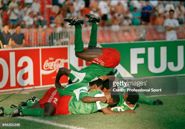 Cameroon players pile on top of each other as they celebrate the winning goal scored by Roger Milla during the 1990 FIFA World Cup 2nd Round match...
