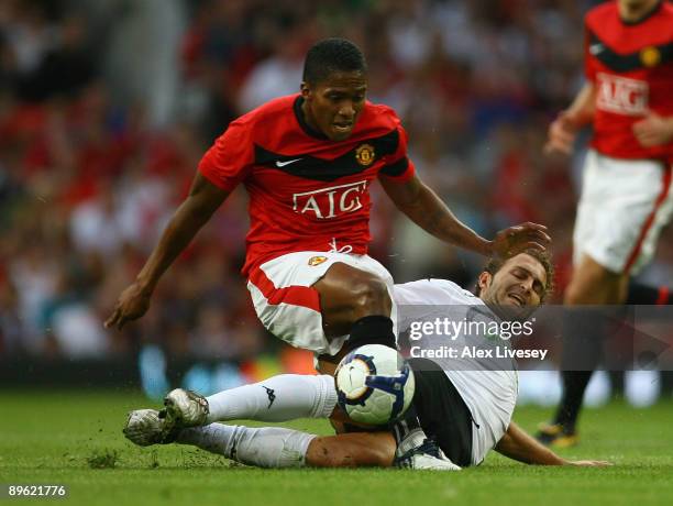 Antonio Valencia of Manchester United is tackled by Ruben Baraja of Valencia during a pre season friendly match between Manchester United and...