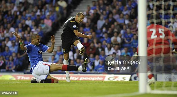 Manchester City's Martin Petrov scores his side's second goal as Rangers' Madjid Bougherra attempts tackle during their friendly soccer match at...