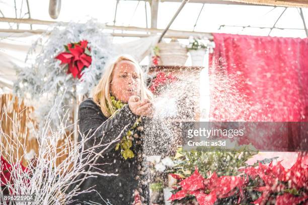 woman blowing artificial snow - fake snow stock pictures, royalty-free photos & images