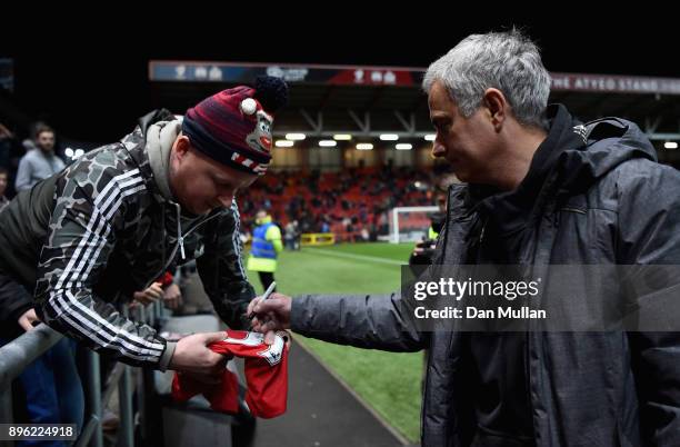 Jose Mourinho, Manager of Manchester United signs a fan's shirt prior to the Carabao Cup Quarter-Final match between Bristol City and Manchester...