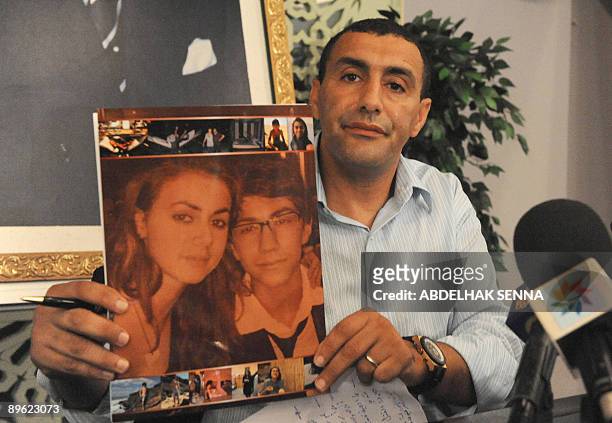 Former champion athlete, Moroccan Khalid Skah, shows a photo of his daughter Salma and son Tarik as he holds a press conference in Rabat on August 5,...