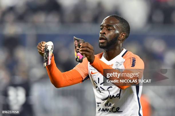 Montpellier's French forward Jonathan Ikone holds pictures as he celebrates scoring a goal during the French L1 football match between Bordeaux and...