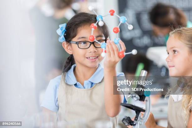 schoolgirl studies molecular structure during class - kid scientist stock pictures, royalty-free photos & images