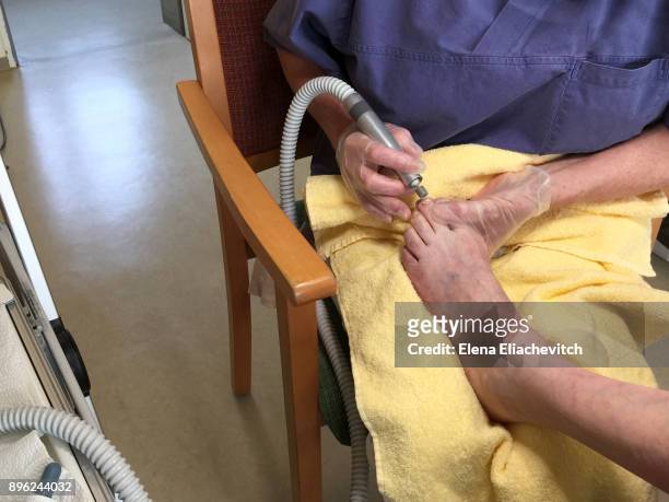 mature lady gets foot care at home. - eliachevitch stock pictures, royalty-free photos & images