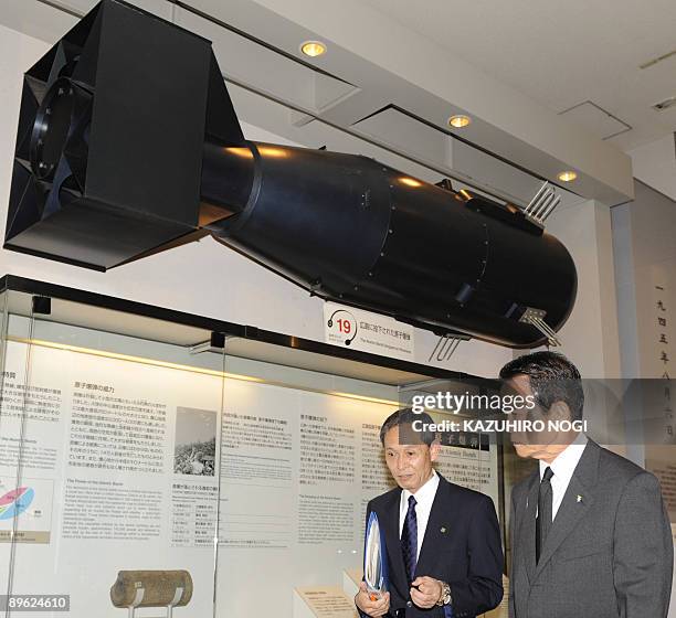 Japanese Prime Minister Taro Aso walks under a model of the atomic bomb which was used in the world's first atomic bombing in Hiroshima in 1945...