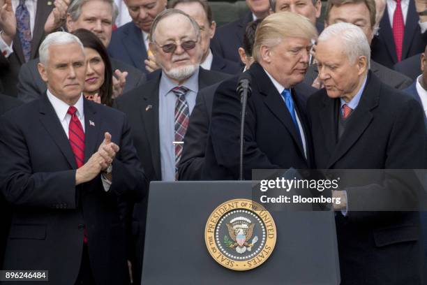 President Donald Trump, center, shakes hands with Senator Orrin Hatch, a Republican from Utah and chairman of the Senate Finance Committee, during a...