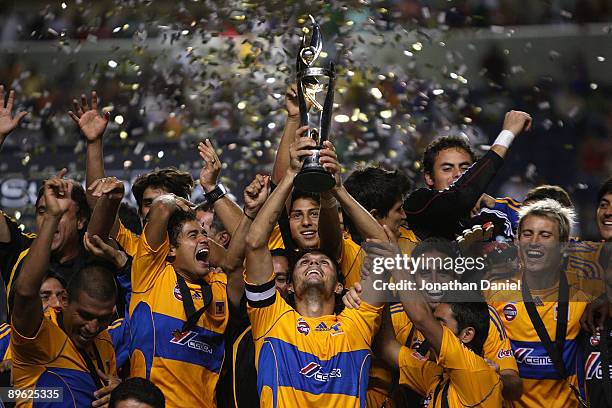 Fernando Ortiz of Tigres UANL holds the trophy as his teammates celebrate winning the SuperLiga 2009 Final over the Chicago Fire on August 5, 2009 at...