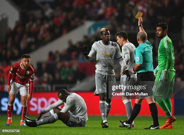 Paul Pogba of Manchester United is booked by referee Mike Dean during the Carabao Cup Quarter-Final match between Bristol City and Manchester United...