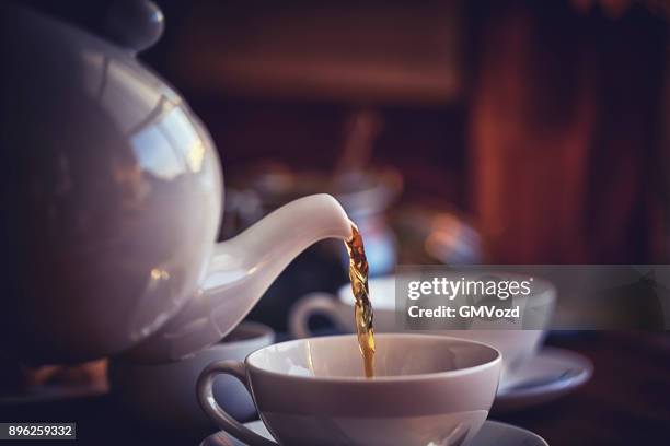 kopje zwarte thee geserveerd met koekjes - theepot stockfoto's en -beelden