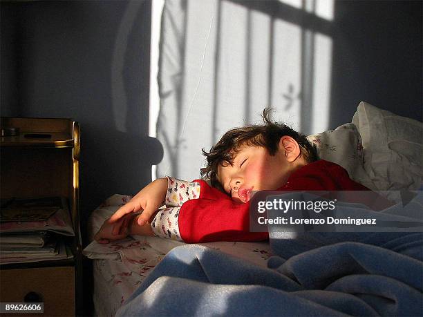 sleeping boy in red pajamas - kids sleep in bed stock-fotos und bilder