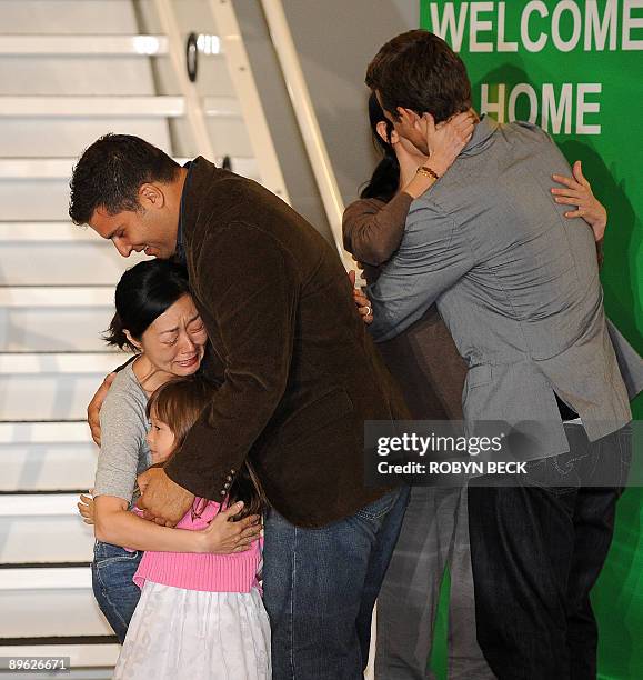 Freed US journalist Euna Lee embraces her husband Michael Saldate and daughter Hana and US journalist Laura Ling embraces her husband Iain Clayton...