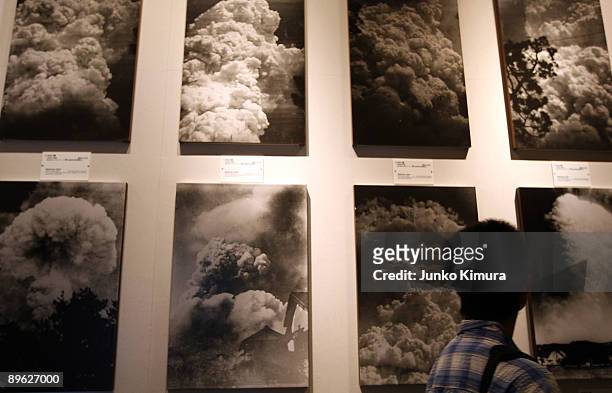 Visitor passes by pictures displaying the mushroom cloud pictured when the atomic bomb was dropped at the Peace Memorial Museum on August 6, 2009 in...