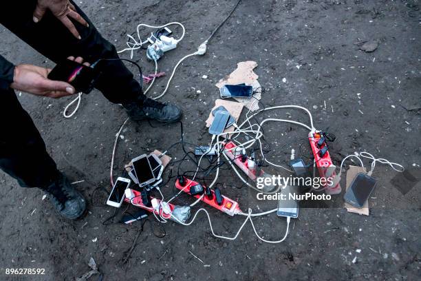 Immigrants are charging their mobile phones in the plugs provided for them by humanitarian charities operating in Calais, France on December 19, 2017.