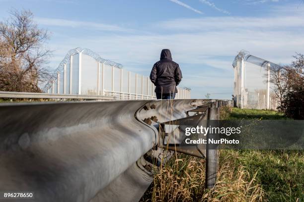 An immigrant is walking on a road towards fences which surround border zone in Calais, France on December 19, 2017.