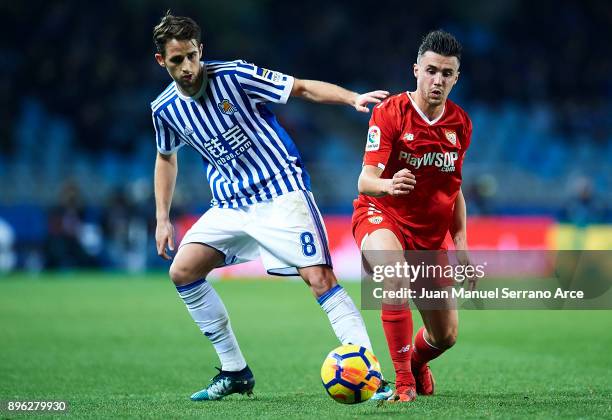 Sebastien Corchia of Sevilla FC being followed by Adnan Januzaj of Real Sociedad during the La Liga match between Real Sociedad and Sevilla at...