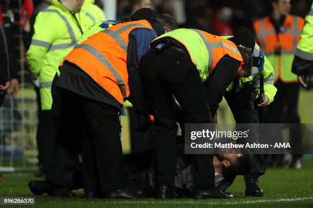 Manchester United fan is restrained during the Carabao Cup Quarter-Final match between Bristol City and Manchester United at Ashton Gate on December...