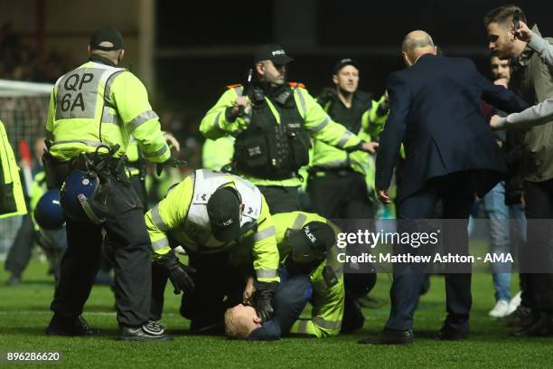 Manchester United fan is restrained at the end of the Carabao Cup Quarter-Final match between Bristol City and Manchester United at Ashton Gate on...