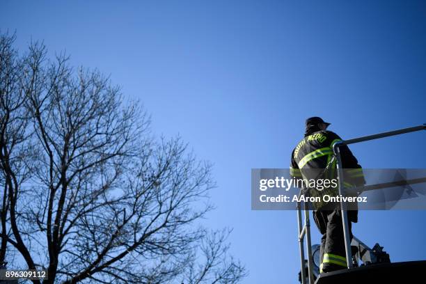 Engineer Dennis Lawrence stands on the ladder truck at station 35 as he and fellow firefighters test their equipment on December 19, 2017. South...