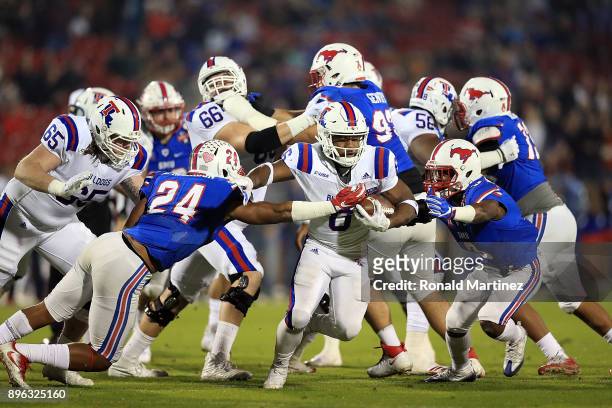 Boston Scott of the Louisiana Tech Bulldogs runs the ball against Delano Robinson and Cedric Lancaster of the Southern Methodist Mustangs in the...
