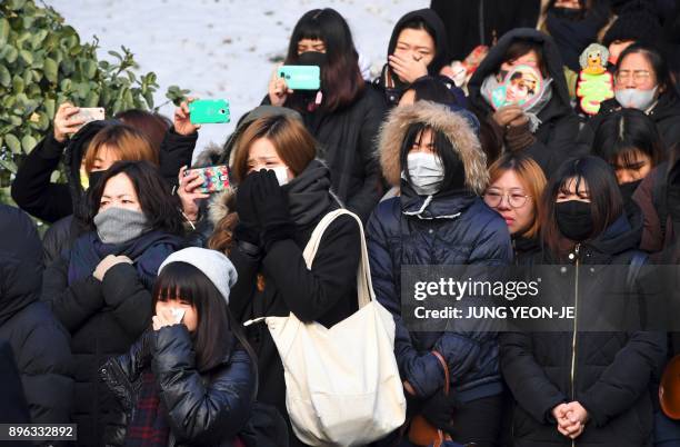 Fans of late SHINee singer Kim Jong-Hyun cry as the hearse carrying the body of Kim Jong-Hyun leaves from a hospital in Seoul on December 21, 2017....