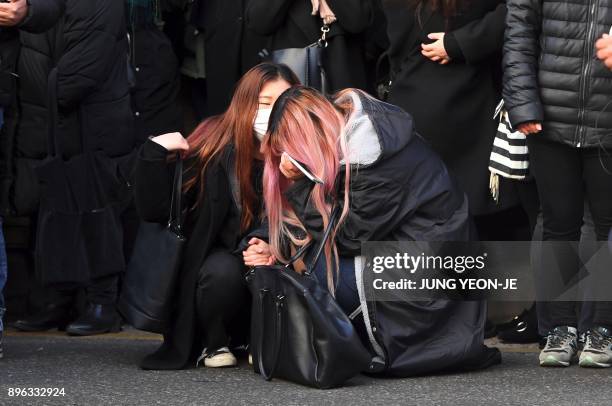 Fans of late SHINee singer Kim Jong-Hyun cry as the hearse carrying the body of Kim Jong-Hyun leaves from a hospital in Seoul on December 21, 2017....