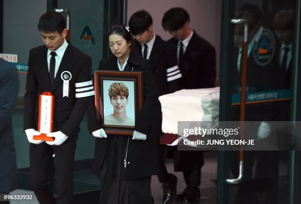 Family members and friends of late SHINee singer Kim Jong-Hyun carry out his coffin during a funeral at a hospital in Seoul on December 21, 2017....