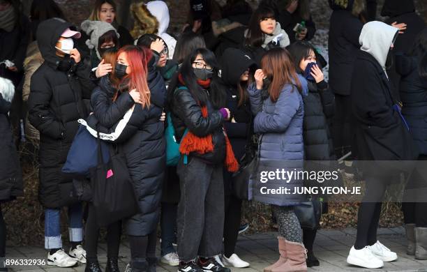 Fans of late SHINee singer Kim Jong-Hyun cry as the hearse carrying the body of Kim Jong-Hyun leaves from a hospital in Seoul on December 21, 2017....