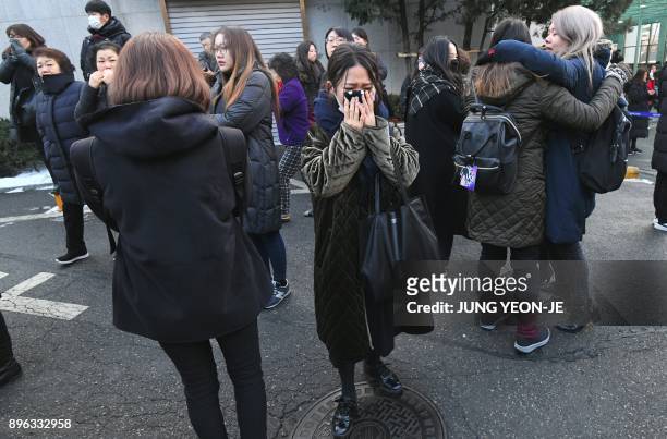 Fans of late SHINee singer Kim Jong-Hyun cry as the hearse carrying the body of Kim Jong-Hyun leaves from a hospital in Seoul on December 21, 2017....