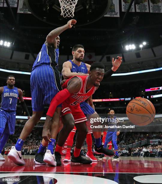 Bobby Portis of the Chicago Bulls looses control of the ball under pressure from Jonathon Simmons and Nikola Vucevic of the Orlando Magic at the...