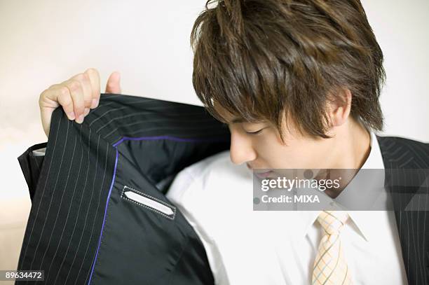 young businessman sniffing his underarm - smelling armpit stock pictures, royalty-free photos & images