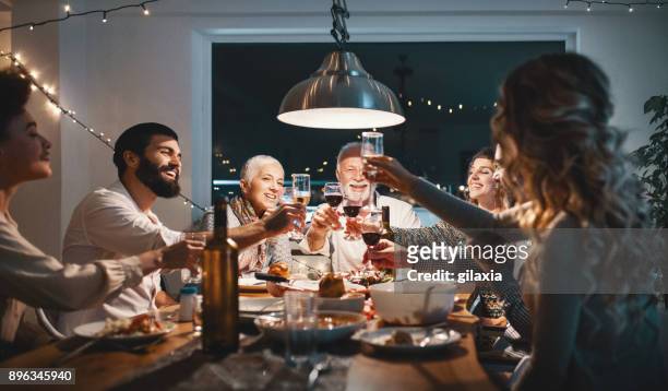 family having dinner on christmas eve. - dinner party stock pictures, royalty-free photos & images