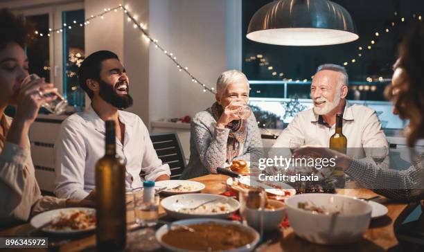 family having dinner on christmas eve. - eve party stock pictures, royalty-free photos & images