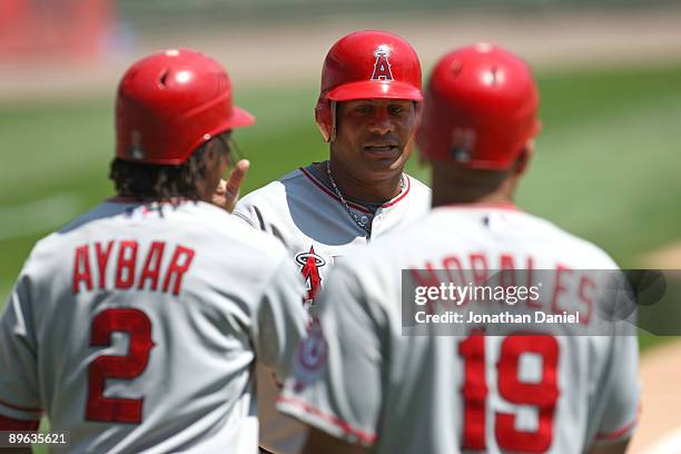 Erick Aybar, Bobby Abreu and Kendry Morales of the Los Angeles Angels of Anaheim celebrate at home plate after Aybar and Abreu scored on a throwing...