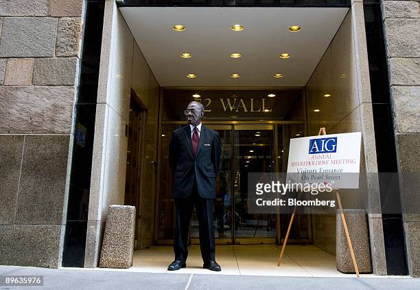 Security guard stands next to a sign guiding attendees to the American International Group Inc. Shareholders meeting in New York, U.S., on Tuesday,...