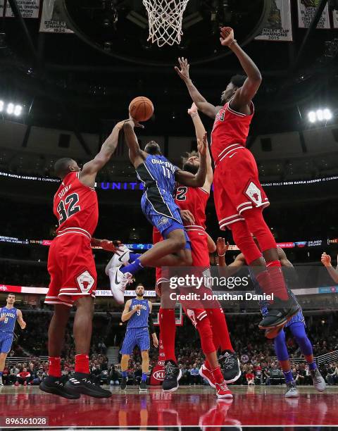 Jonathon Simmons of the Orlando Magic puts up a shot between Kris Dunn, Robin Lopez and Justin Holiday of the Chicago Bulls at the United Center on...