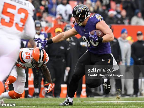 Tight end Nick Boyle of the Baltimore Ravens stiff-arms safety Derrick Kindred of the Cleveland Browns, as he carries the ball downfield in the first...