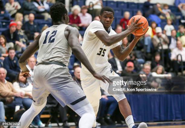 George Washington Colonials forward Bo Zeigler charges in on New Hampshire Wildcats forward Iba Camara during a college basketball game on December...